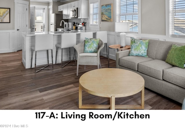 117 W Bogue Blvd, Atlantic Beach, NC 28512 - living room with a wainscoted wall, dark wood-style flooring, and a decorative wall