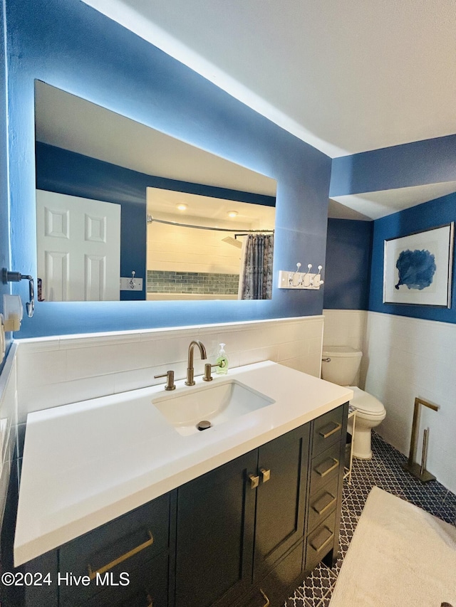 bathroom featuring vanity, tile patterned floors, toilet, tile walls, and curtained shower