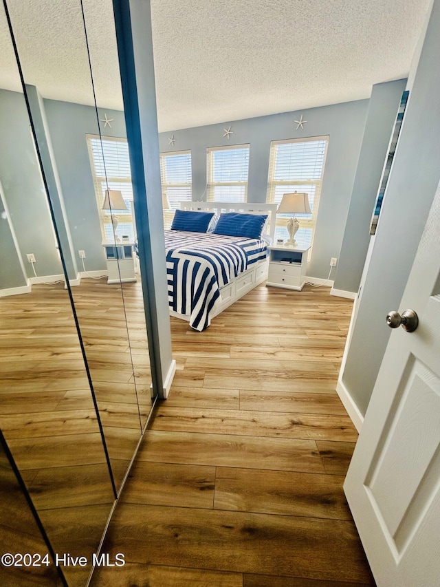 bedroom featuring a textured ceiling, light hardwood / wood-style flooring, and a closet