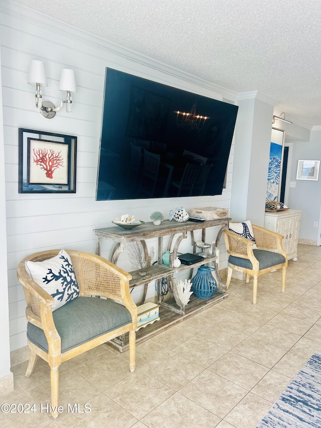 sitting room with crown molding, light tile patterned floors, and a textured ceiling