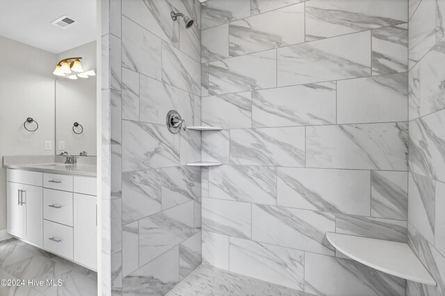 2765 Longleaf Pine Cir, Leland, NC 28451 - bathroom featuring marble finish floors, double vanity, and a tile shower