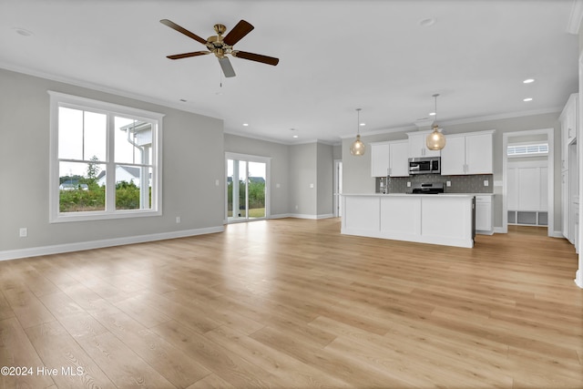 unfurnished living room featuring ceiling fan, ornamental molding, and light hardwood / wood-style flooring