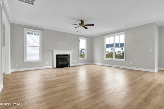 unfurnished living room with a wealth of natural light, light hardwood / wood-style flooring, ceiling fan, and crown molding