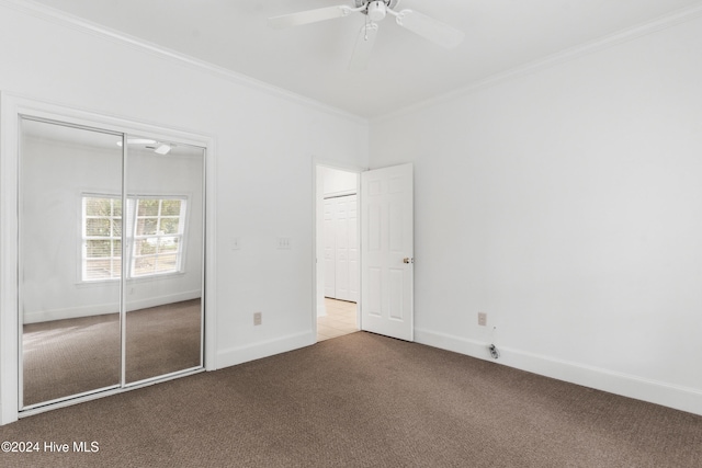 unfurnished bedroom featuring ceiling fan, a closet, carpet floors, and ornamental molding