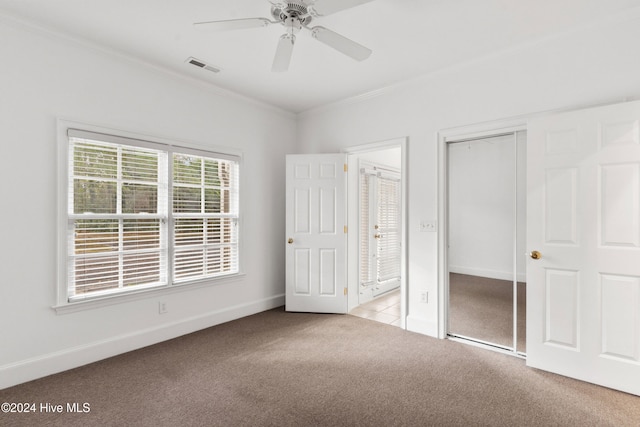 unfurnished bedroom with light colored carpet, ceiling fan, and crown molding