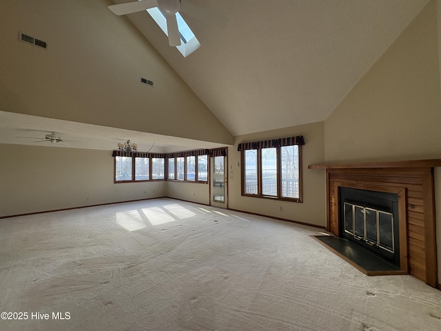 unfurnished living room with light carpet, a skylight, high vaulted ceiling, and ceiling fan