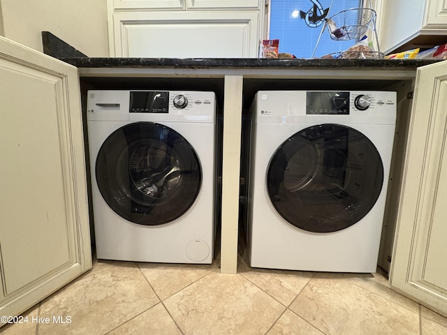 laundry area with cabinets, separate washer and dryer, and light tile patterned floors