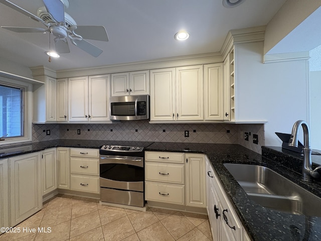 kitchen featuring sink, tasteful backsplash, dark stone counters, light tile patterned floors, and appliances with stainless steel finishes