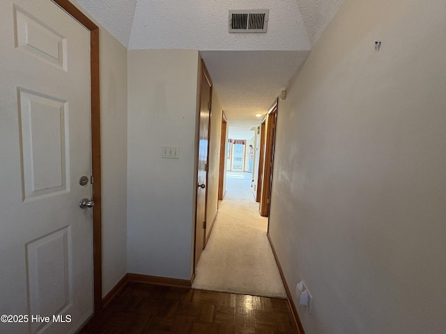 corridor featuring dark parquet floors and a textured ceiling