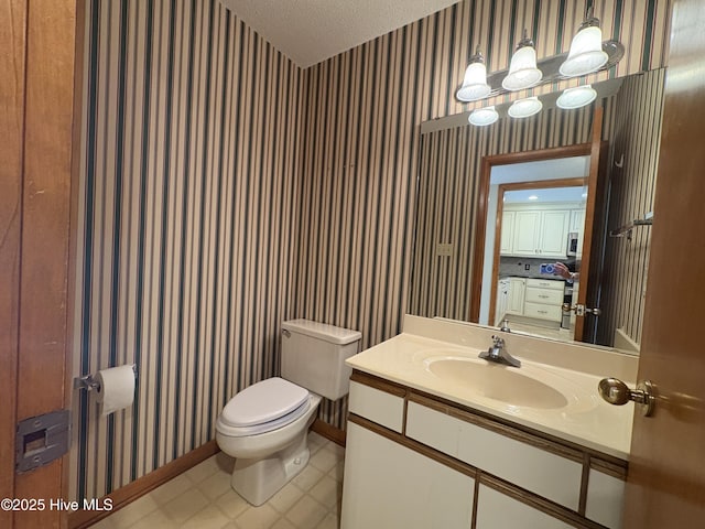 bathroom with vanity, a textured ceiling, and toilet