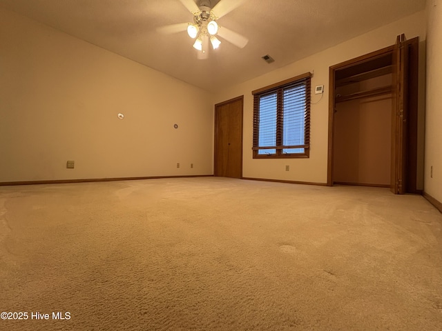 unfurnished bedroom featuring light carpet, vaulted ceiling, and ceiling fan