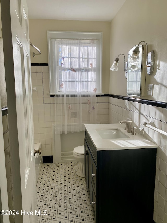 full bathroom featuring vanity, toilet, tile walls, and tub / shower combination