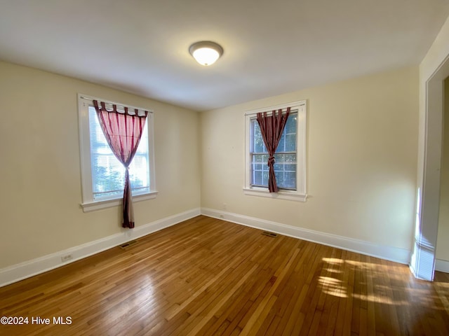 unfurnished room with wood-type flooring