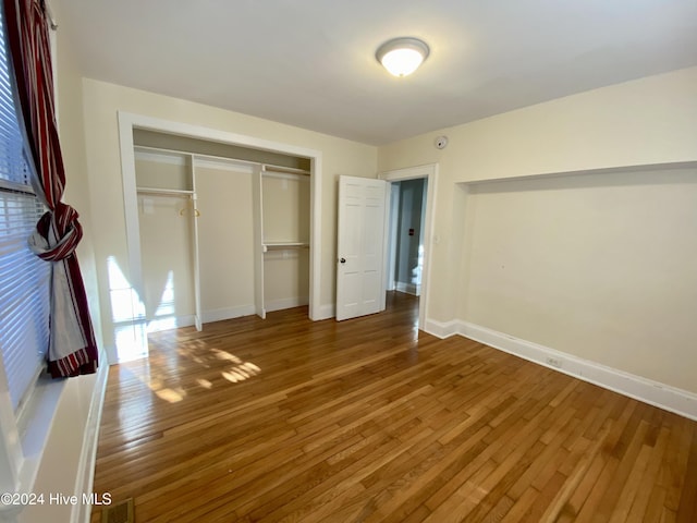 unfurnished bedroom featuring hardwood / wood-style floors and a closet