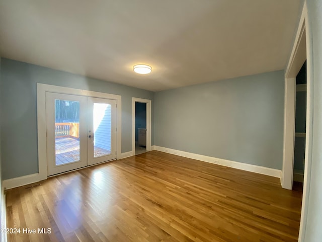 empty room with french doors and wood-type flooring