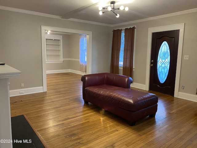 entrance foyer with hardwood / wood-style floors, a notable chandelier, and crown molding