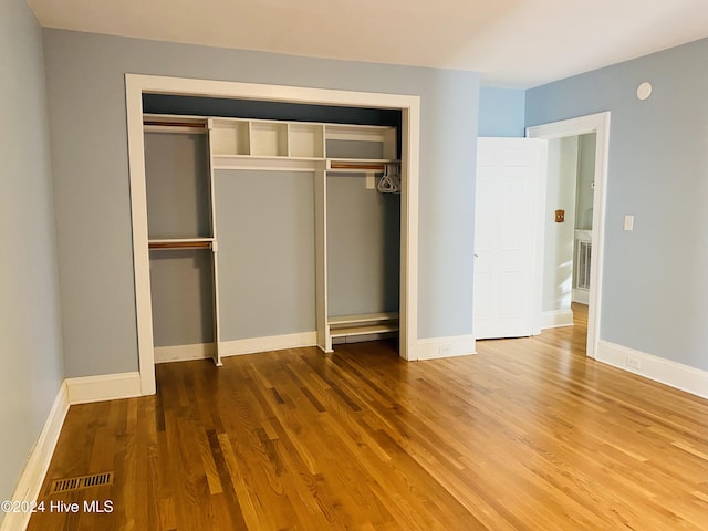 unfurnished bedroom with wood-type flooring and a closet