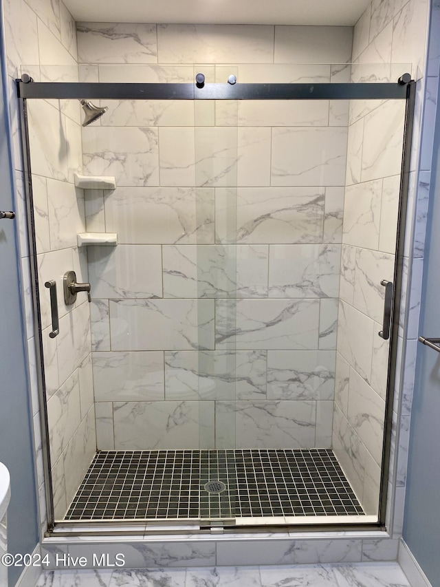 bathroom featuring a shower with door