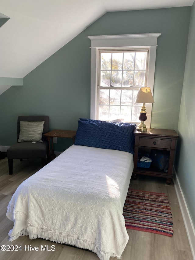 bedroom with hardwood / wood-style flooring and lofted ceiling