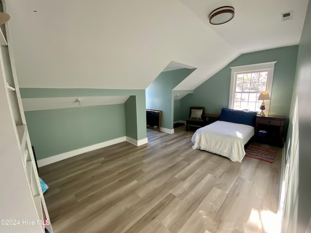 bedroom featuring hardwood / wood-style floors and vaulted ceiling