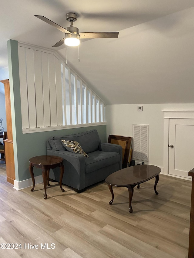 living room with ceiling fan, light hardwood / wood-style floors, and lofted ceiling