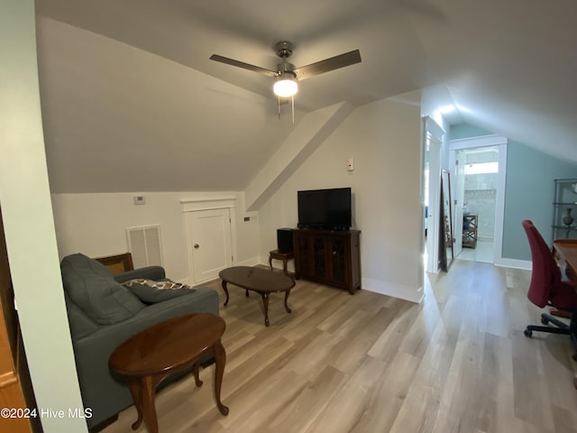 living area featuring light hardwood / wood-style floors, vaulted ceiling, and ceiling fan