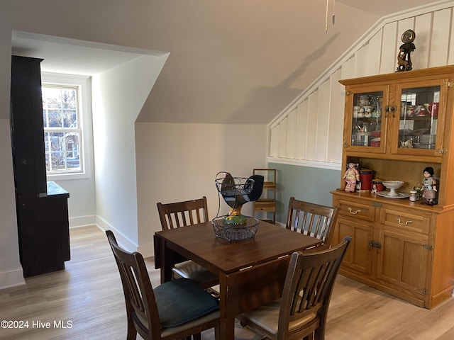 dining space with vaulted ceiling and light wood-type flooring