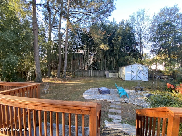 view of yard featuring a shed, a patio area, and a fire pit