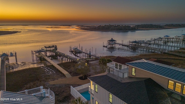 aerial view at dusk featuring a water view