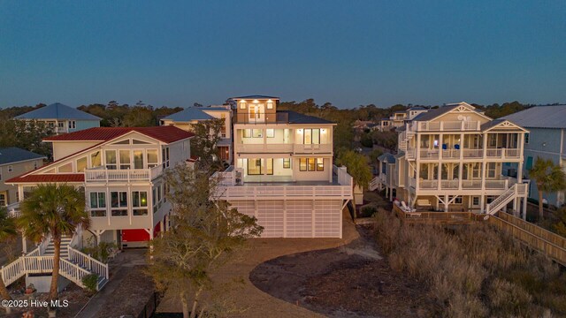 back house at dusk featuring a balcony