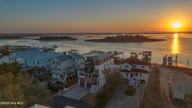 aerial view at dusk featuring a water view