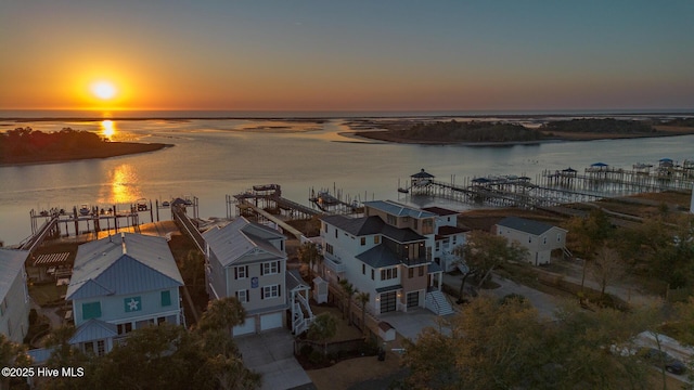 aerial view at dusk featuring a water view