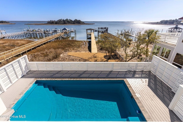 view of swimming pool featuring a water view and a dock