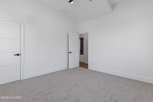 unfurnished room with vaulted ceiling, light colored carpet, and ceiling fan