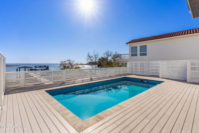 view of pool with a deck with water view