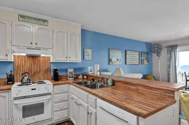 kitchen with white cabinetry, sink, white appliances, and kitchen peninsula