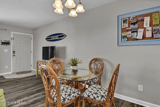 dining space with hardwood / wood-style floors and an inviting chandelier