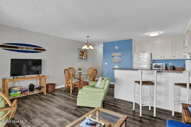 living room featuring dark wood-type flooring and a chandelier