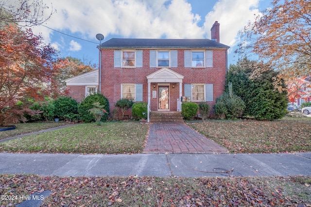 colonial home with a front lawn