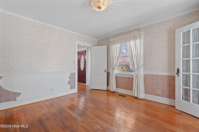 spare room featuring ornamental molding and hardwood / wood-style flooring