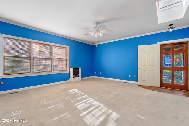 unfurnished living room with ceiling fan, light colored carpet, and crown molding