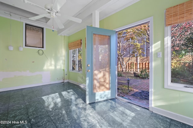 empty room featuring ceiling fan and crown molding