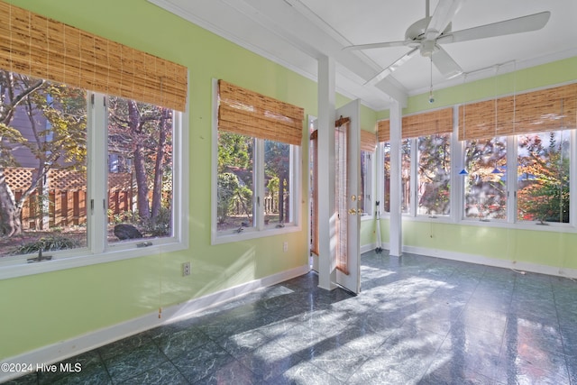 unfurnished sunroom featuring a wealth of natural light and ceiling fan