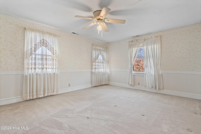 empty room with ceiling fan and light carpet