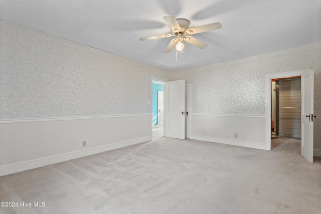 spare room featuring light colored carpet and ceiling fan