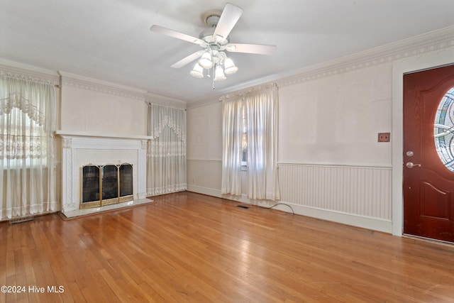 unfurnished living room with a wealth of natural light, wood-type flooring, and a brick fireplace