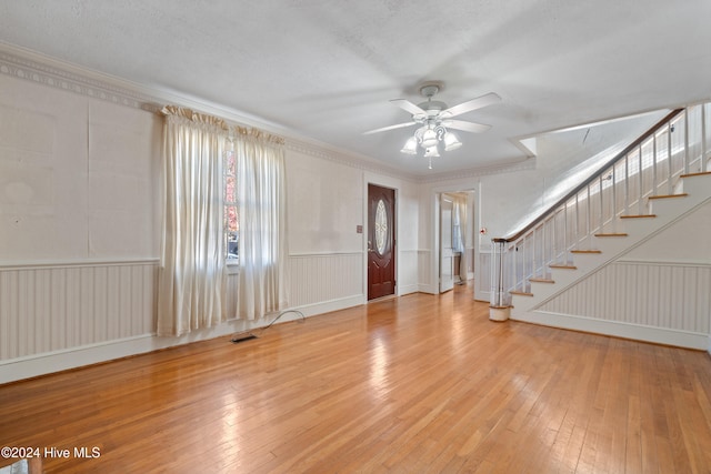 interior space featuring a textured ceiling, light hardwood / wood-style floors, ceiling fan, and crown molding