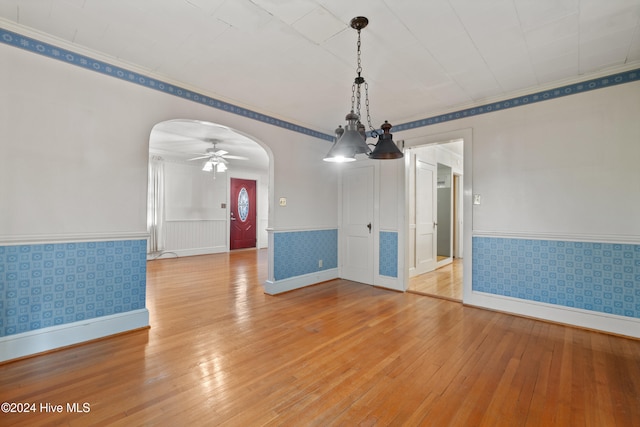 unfurnished dining area with ceiling fan with notable chandelier and light hardwood / wood-style floors