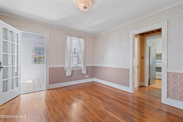 unfurnished room featuring french doors, wood-type flooring, and ornamental molding