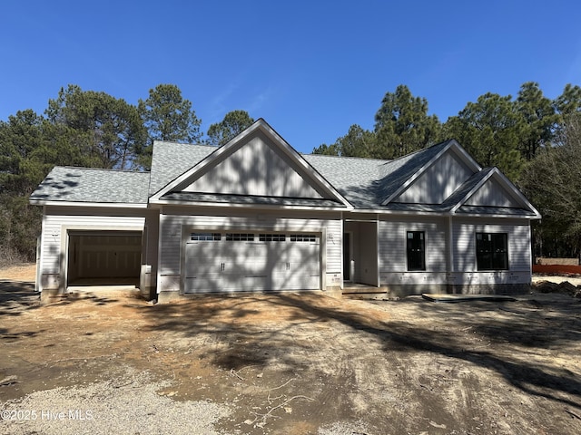 view of front of property with driveway, a standing seam roof, an attached garage, and metal roof